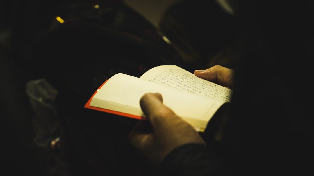 person reading thriller book at night